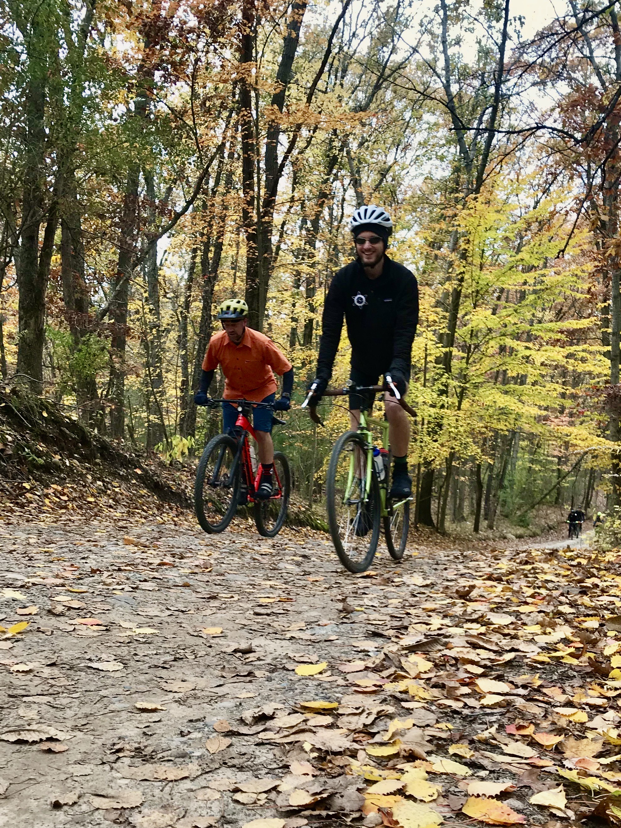 the author, riding a bicycle up a dirt road in autumn